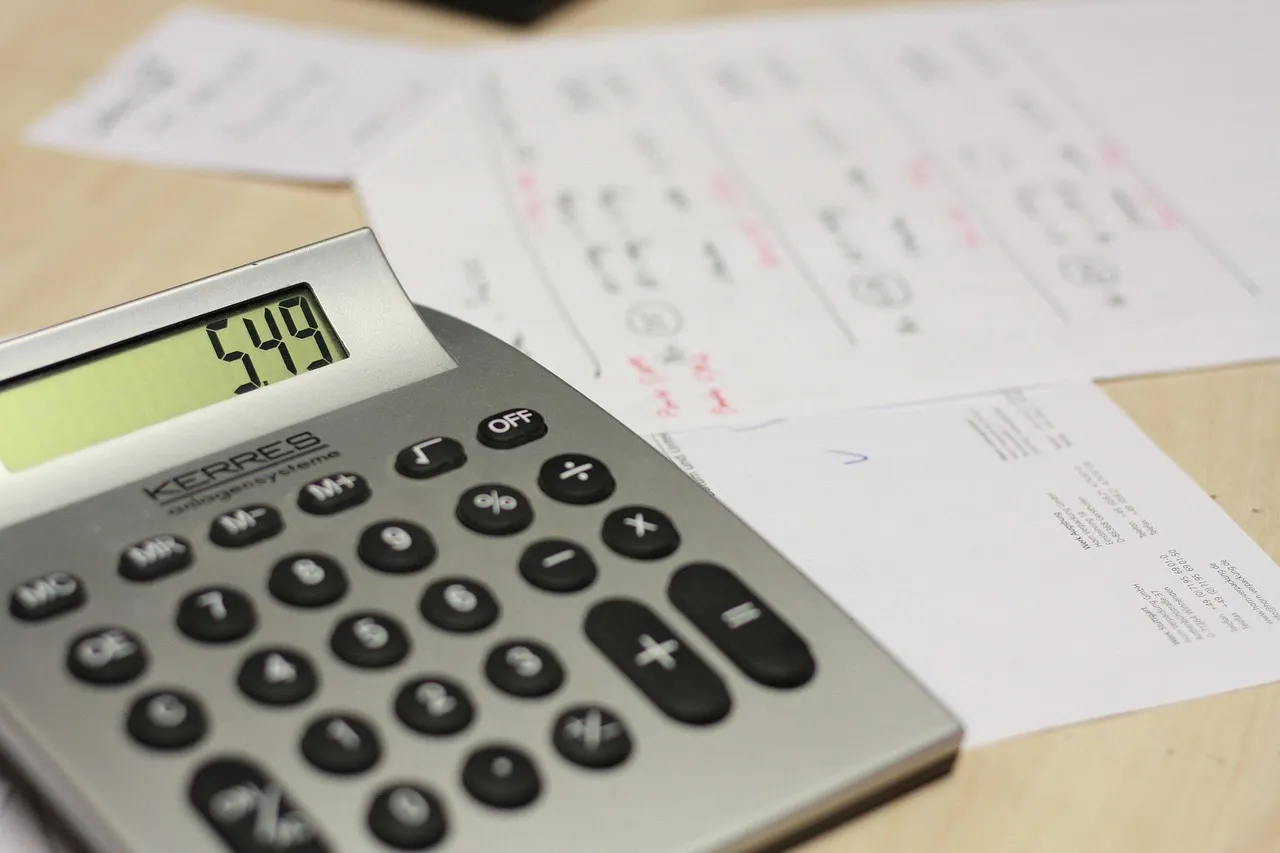 An older person working out household spending with a calculator