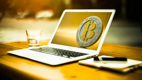 Monety kryptowalut i laptop na biurku