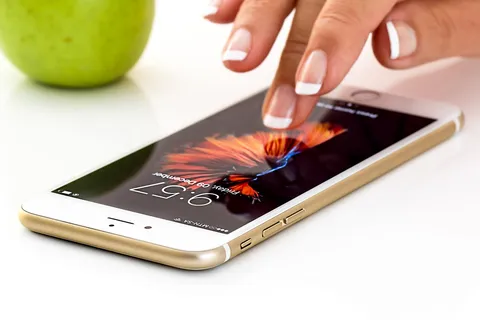 Dłoń trzymająca smartfon z aplikacją