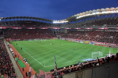 Piłkarze na boisku podczas meczu wieczornego na stadionie