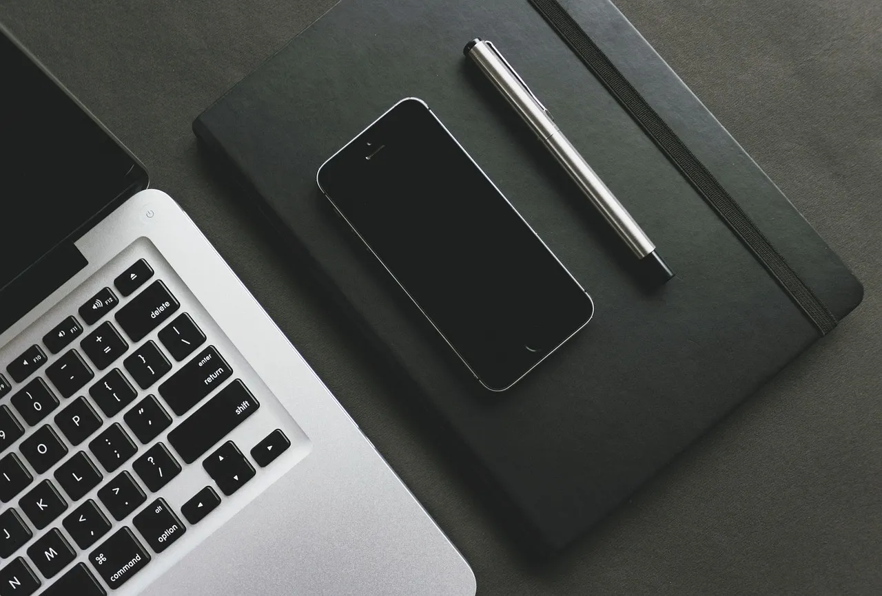 Osoba korzystająca z telefonu i laptopa