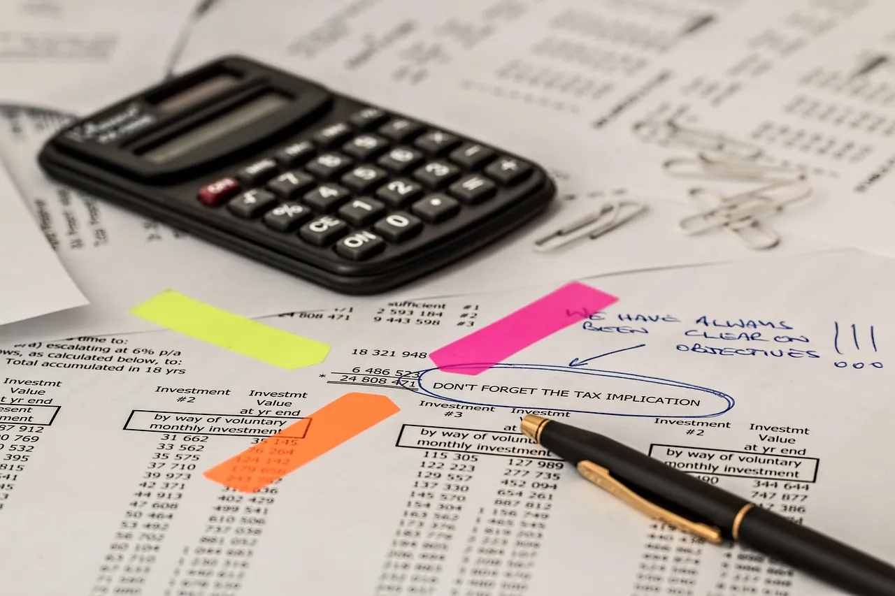 A calculator and tax documents on a desk
