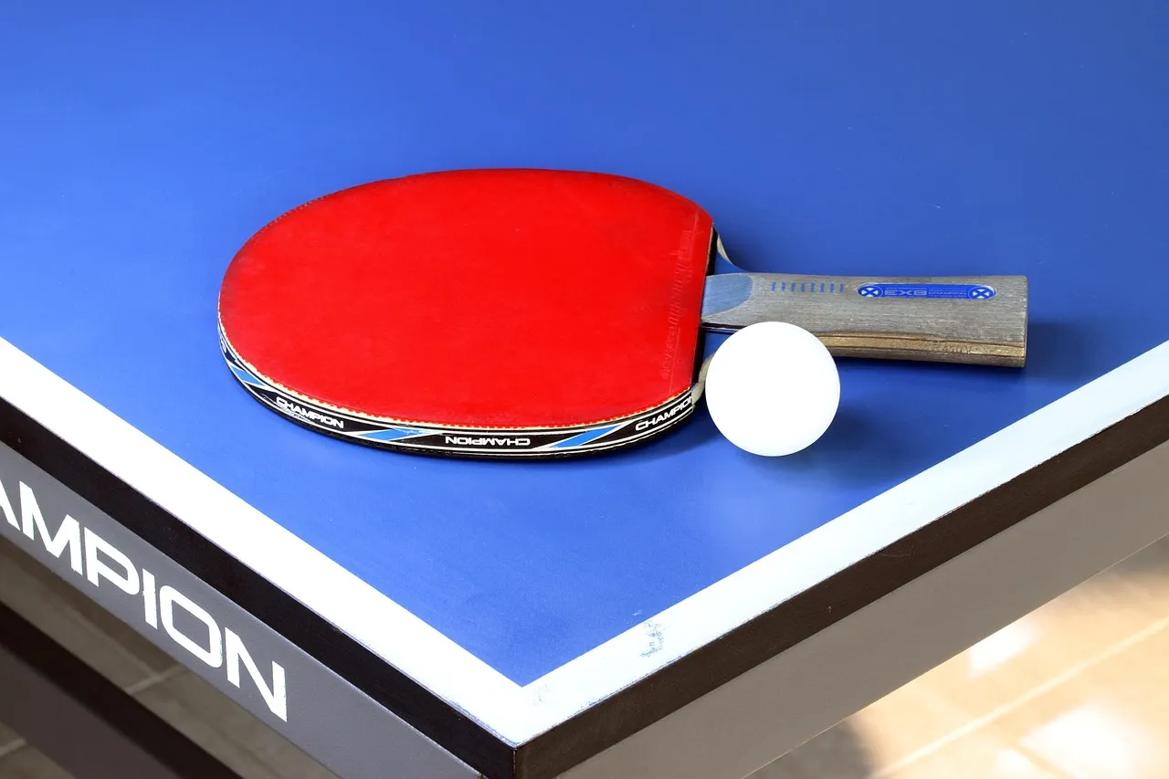 Table tennis paddle and ball on a table