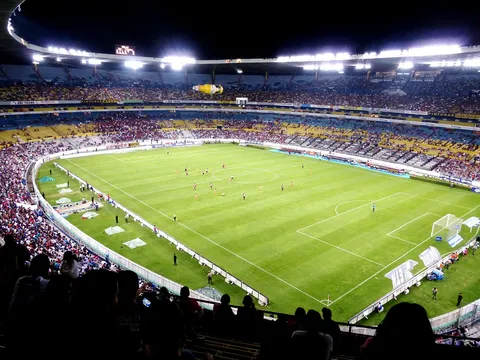 Stadion piłkarski wypełniony kibicami podczas wieczornego meczu
