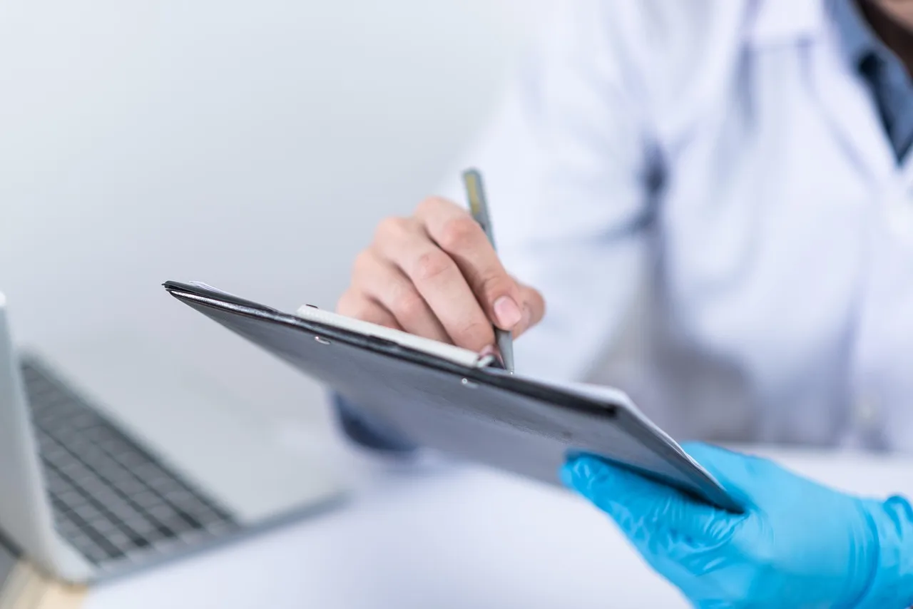 Healthcare worker at a computer with medical records