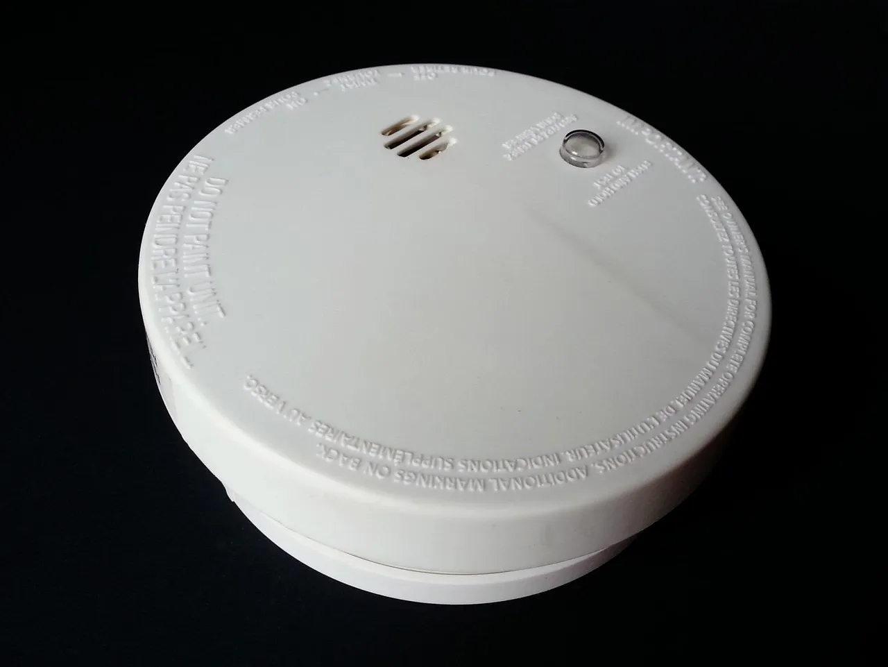 A smoke alarm fitted to a ceiling in a home