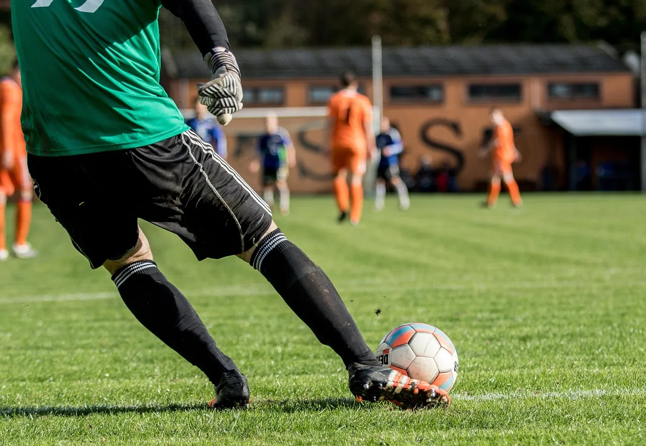 A goalkeeper saves a shot in a handball match