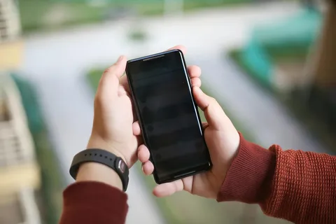 Dłoń trzymająca smartfon z Androidem