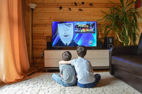 Rodzina oglądająca serial w telewizji w salonie