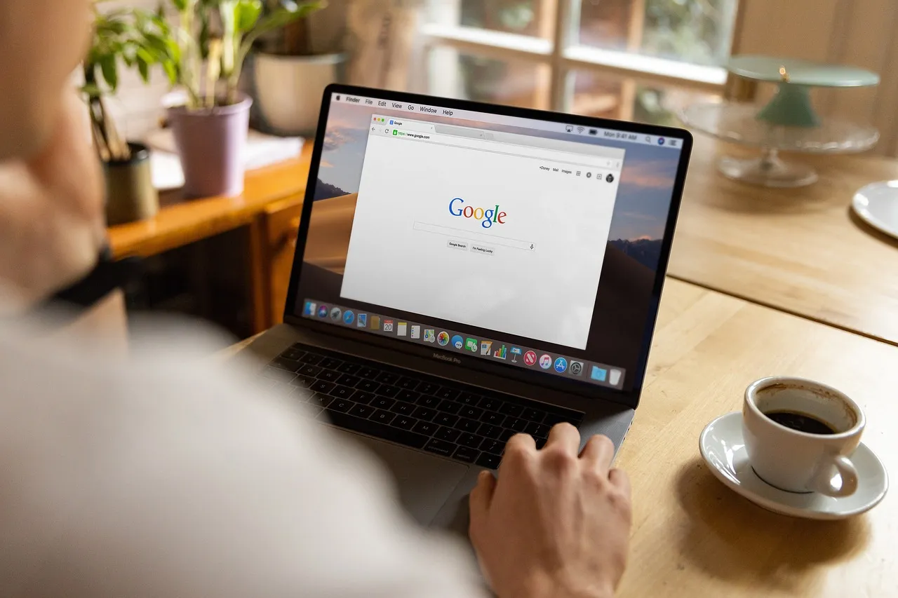 Osoba pracująca na laptopie w kawiarni