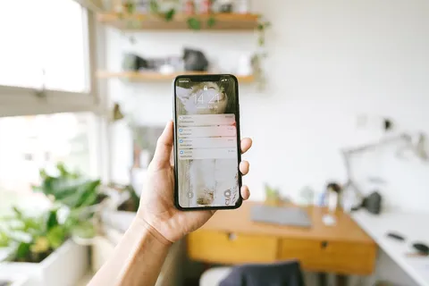 Dłoń trzymająca smartfon z powiadomieniem