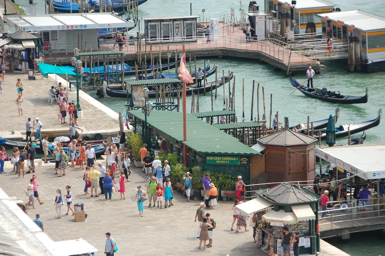A crowd of people beside a canal in a port city