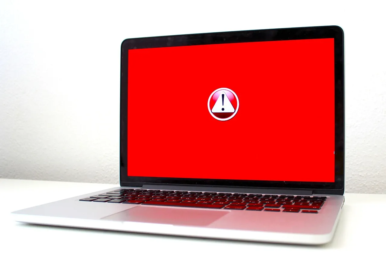 Laptop z ostrzeżeniem o cyberzagrożeniu