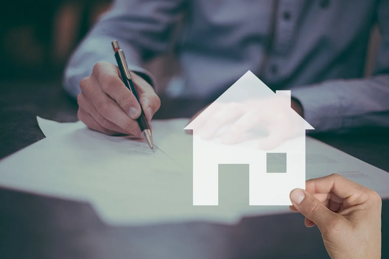 A person signing a loan agreement at a desk
