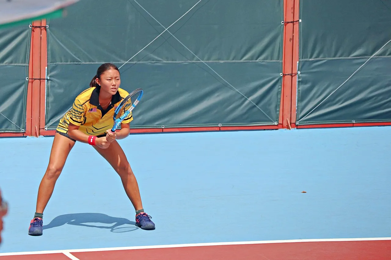 A tennis ball and racket on a hard court