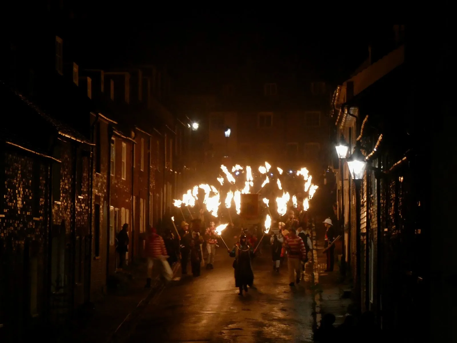 A night-time procession with flaming torches along the narrow Sun Street in Lewes, 4 November 2023